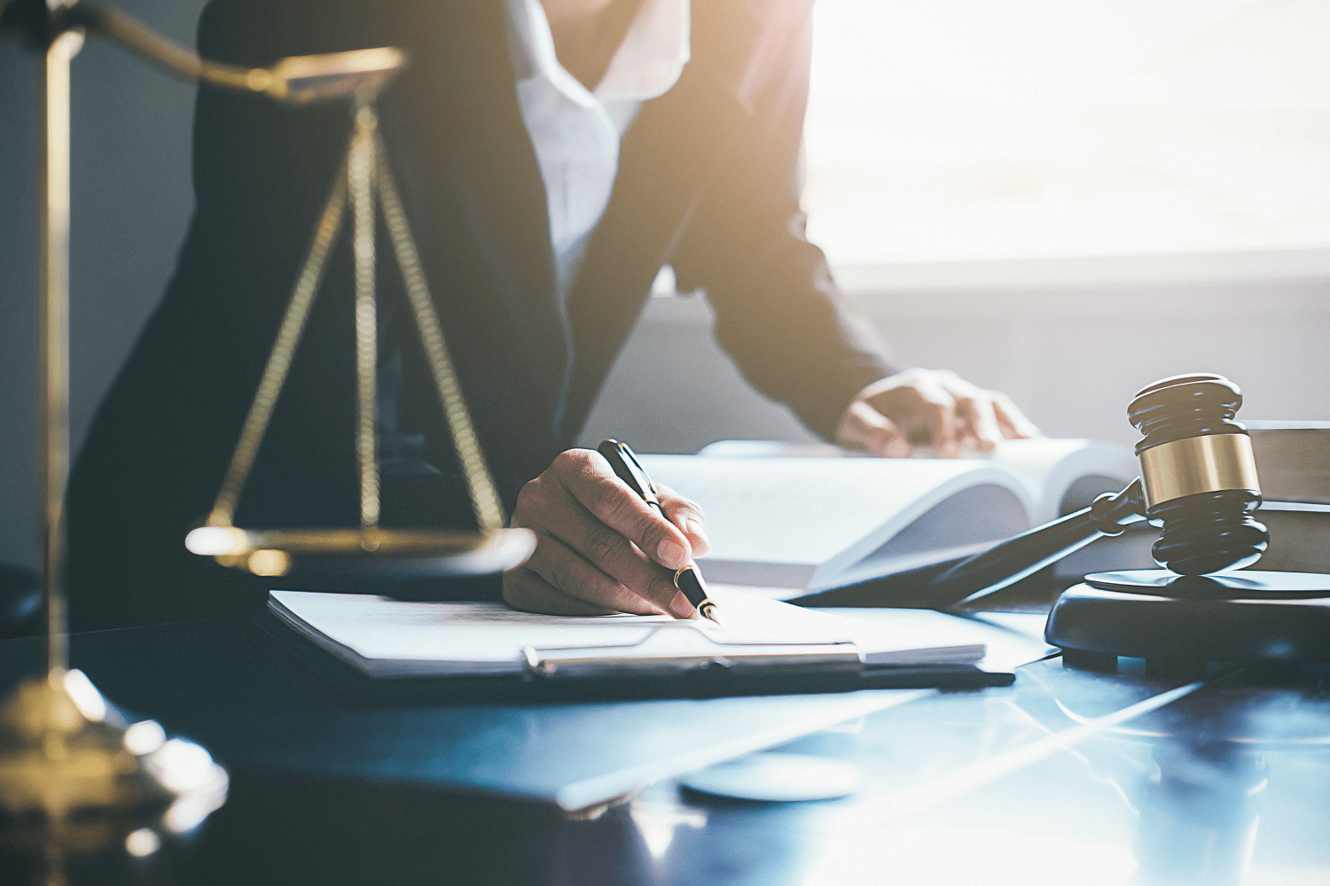 Lawyer writing documents with gavel and scales