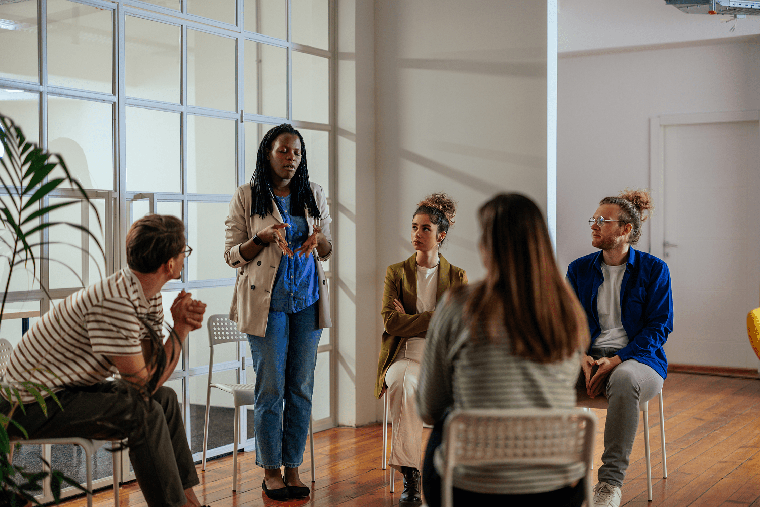Facilitator addressing diverse small group in meeting