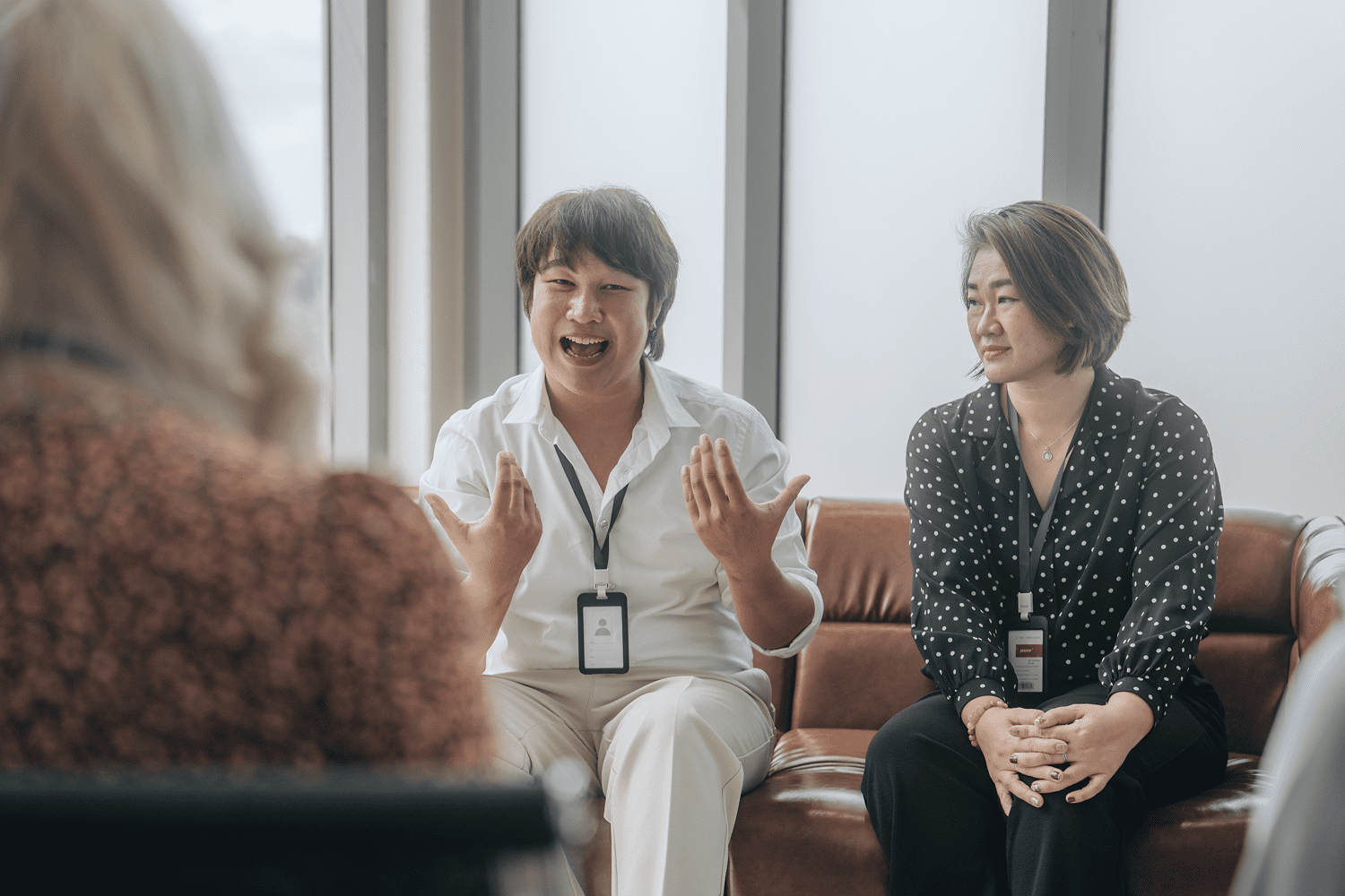 Two colleagues laughing during office meeting
