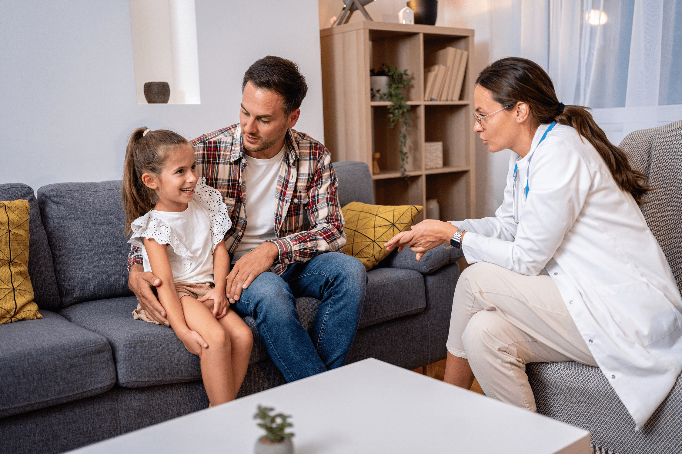 Doctor consulting father and smiling daughter at home