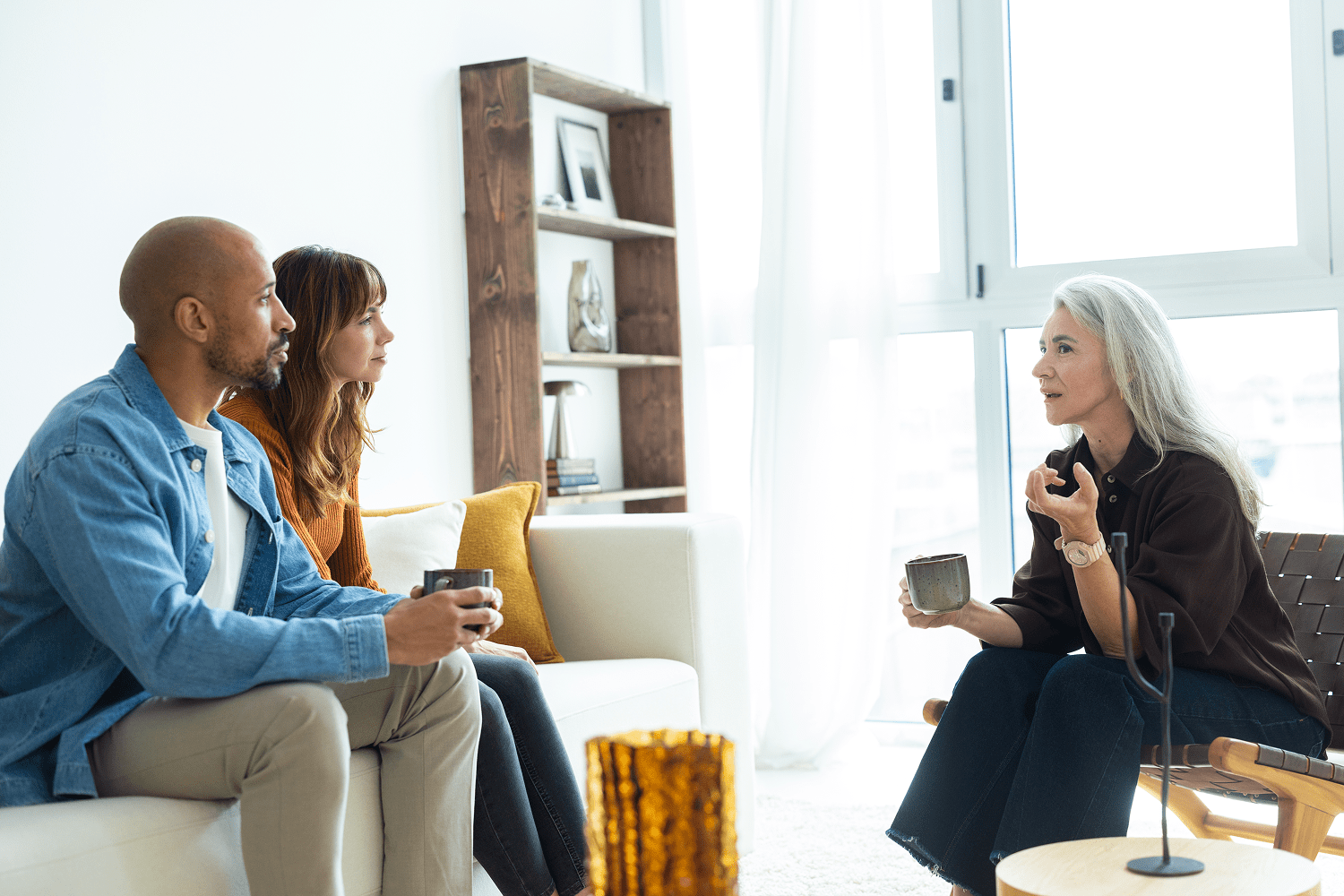 Therapist counseling couple in bright living room