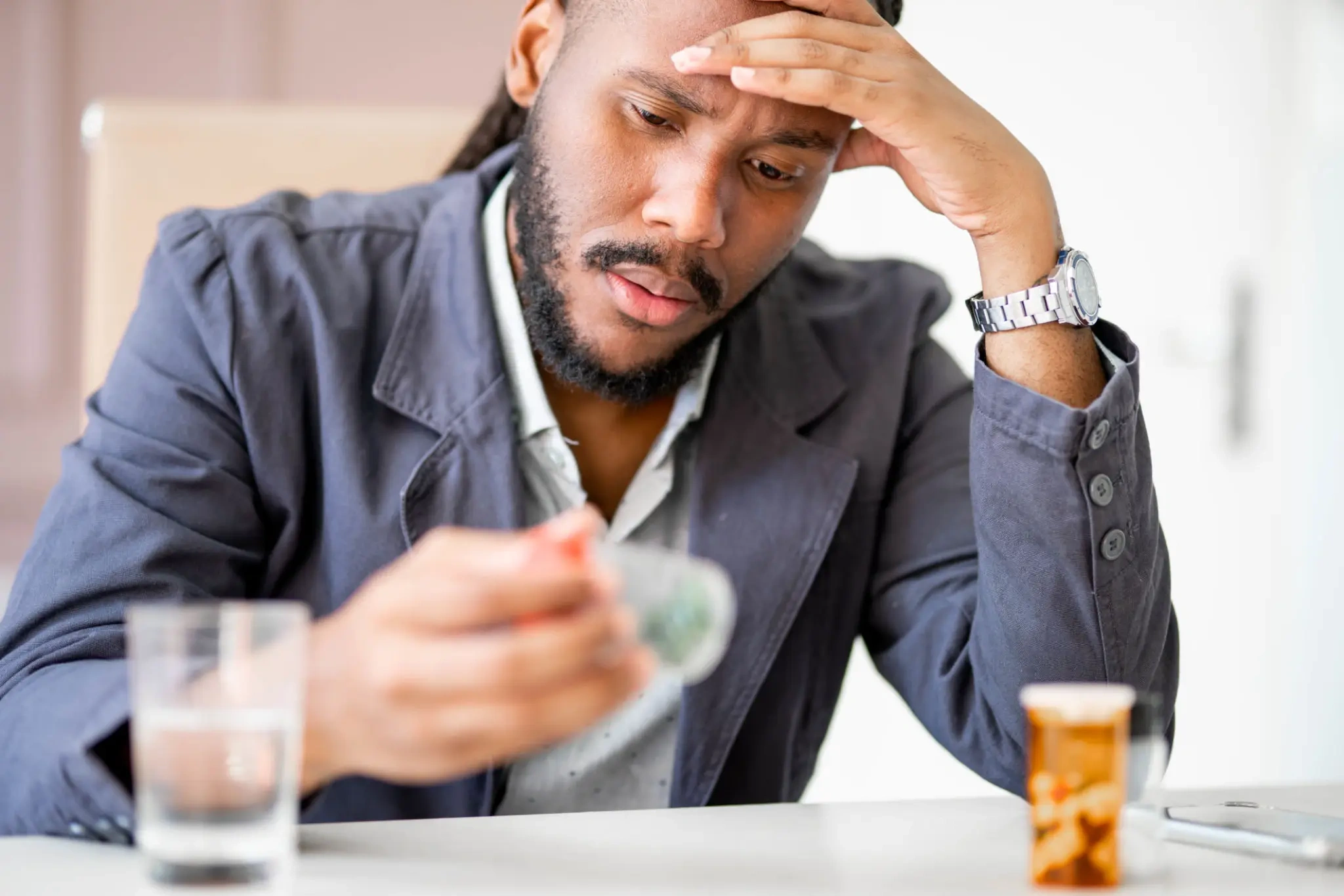 Worried man examining prescription pills