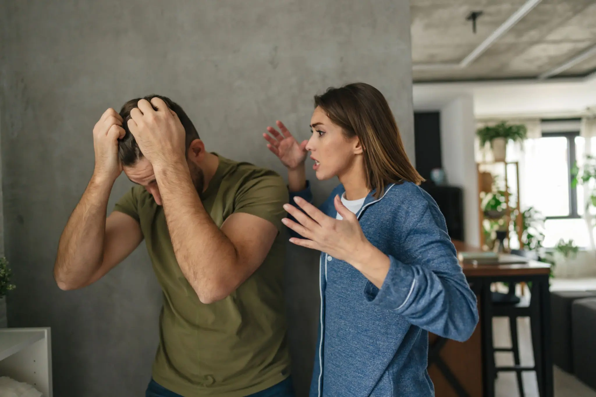 Couple arguing; man covers head in distress