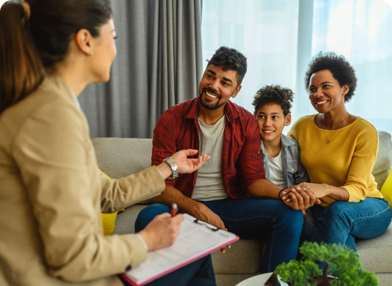 Smiling family meeting with counselor on couch