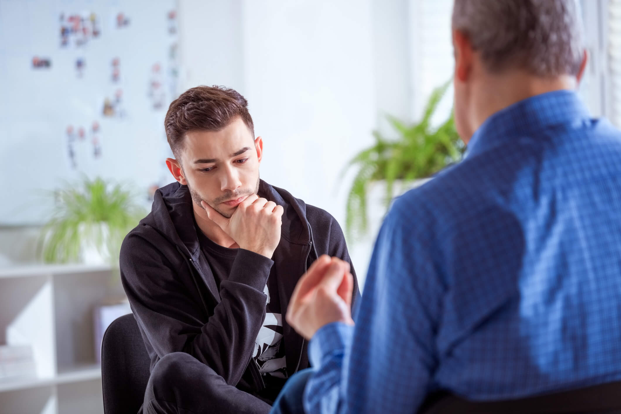 Young man in therapy session listening intently