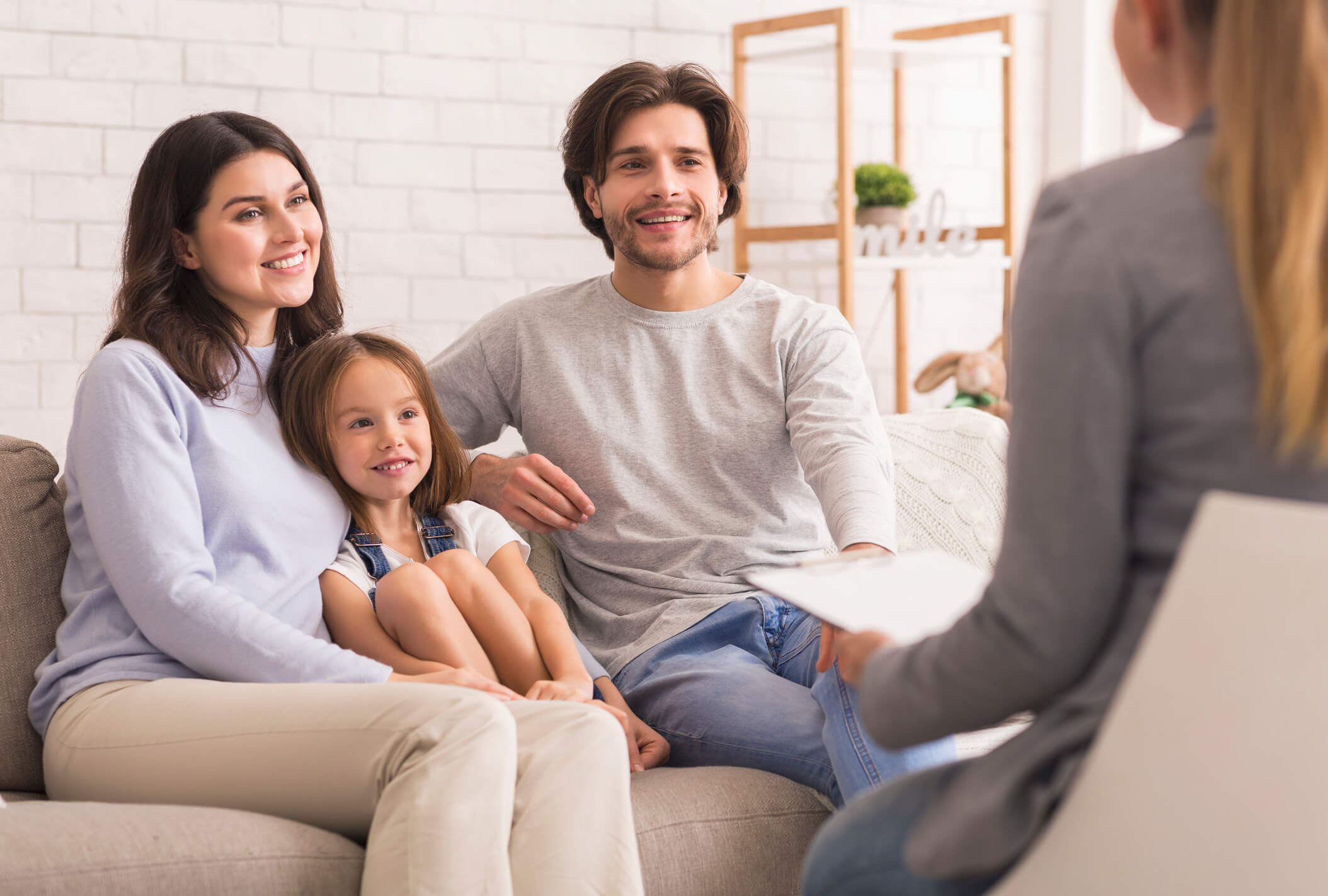 Smiling family consulting with professional on couch