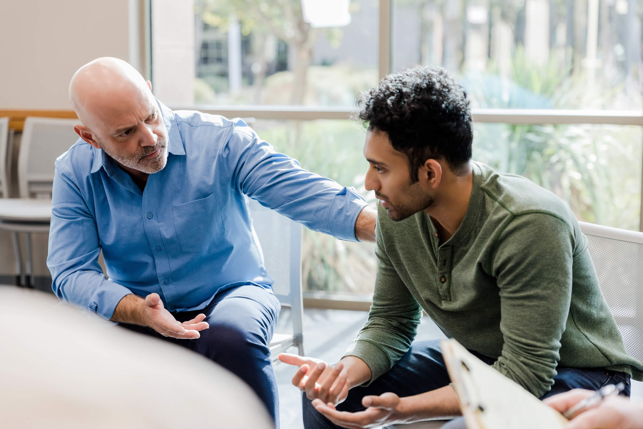Two men in a serious supportive conversation