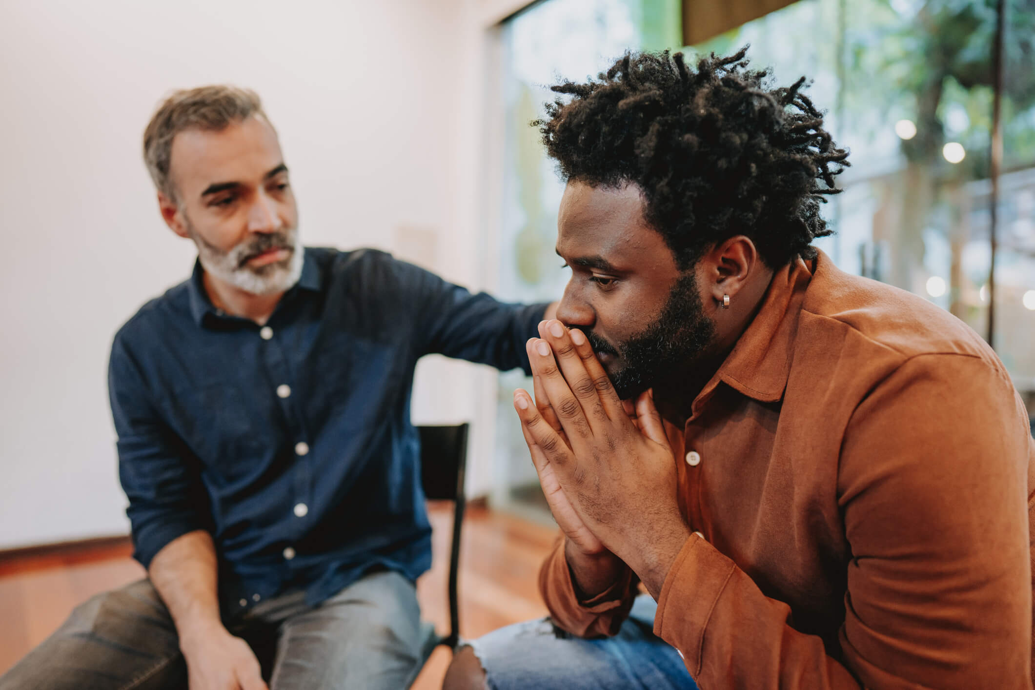 Man being comforted during emotional conversation
