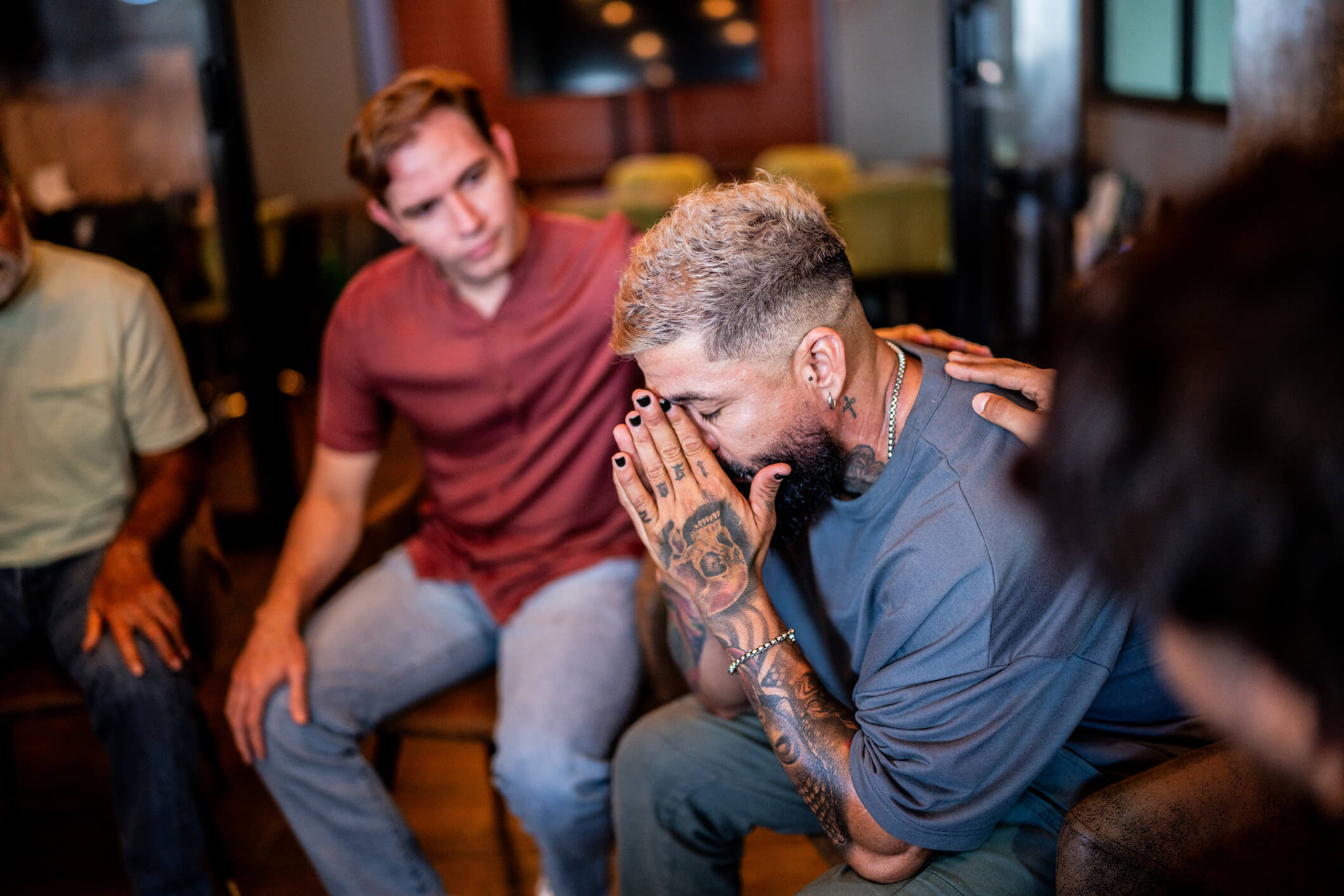 Distressed man comforted by friends in support group