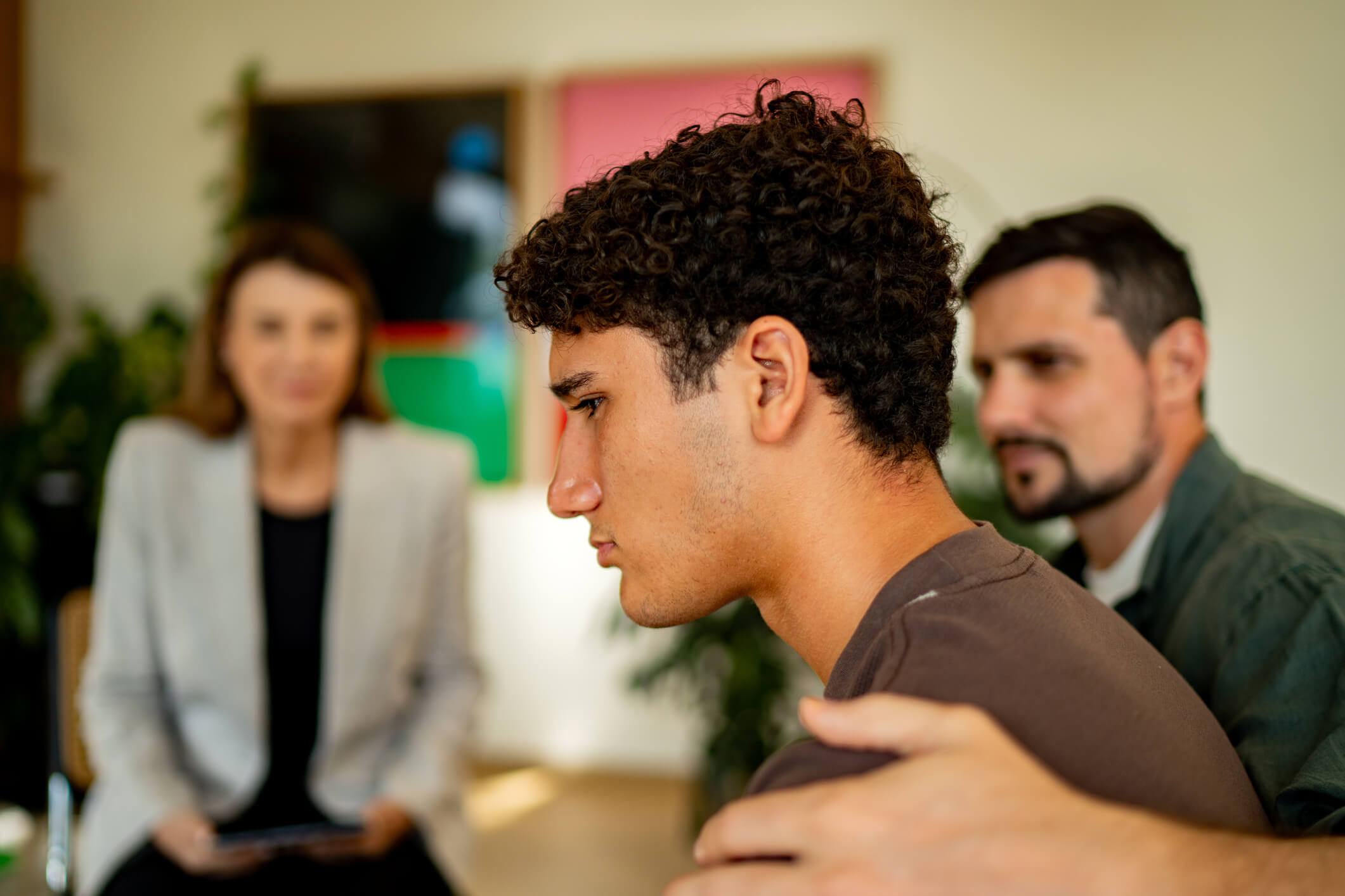 Young man receiving support from two adults